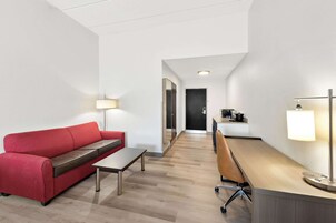 Suíte, 1 cama King e sofá-cama, acessível, para não fumantes | Escrivaninha, espaço de trabalho para notebook, cortinas blackout