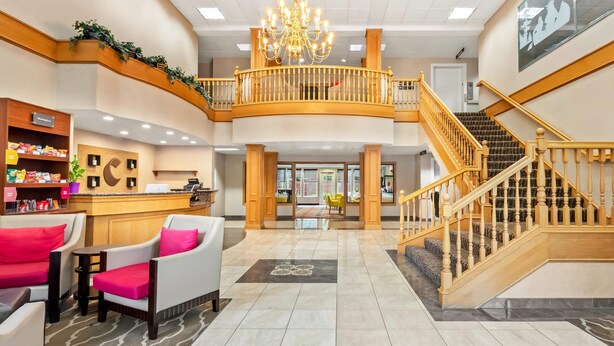 A spacious lobby with a reception desk, seating area, and a staircase leading to an upper level. - Comfort Suites Clackamas (Clackamas)