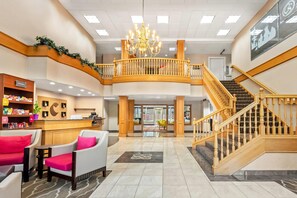 A spacious lobby with a reception desk, seating area, and a staircase leading to an upper level. - Comfort Suites Clackamas (Clackamas)