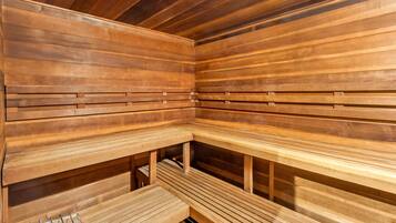 A sauna with wooden benches and a metal rack.