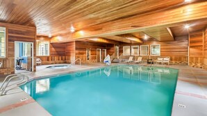 An indoor swimming pool with wooden walls and ceiling, surrounded by lounge chairs and a small hot tub. - Comfort Suites Clackamas (Clackamas)