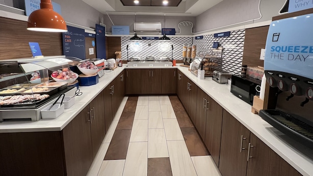 A modern kitchen with a breakfast bar, a coffee machine, and a sign that reads "SQUEEZ THE DAY". - Holiday Inn Express Pittsburgh-Bridgeville by IHG (Bridgeville)