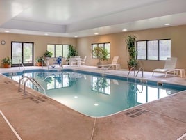 Una piscina techada, sillones reclinables de piscina