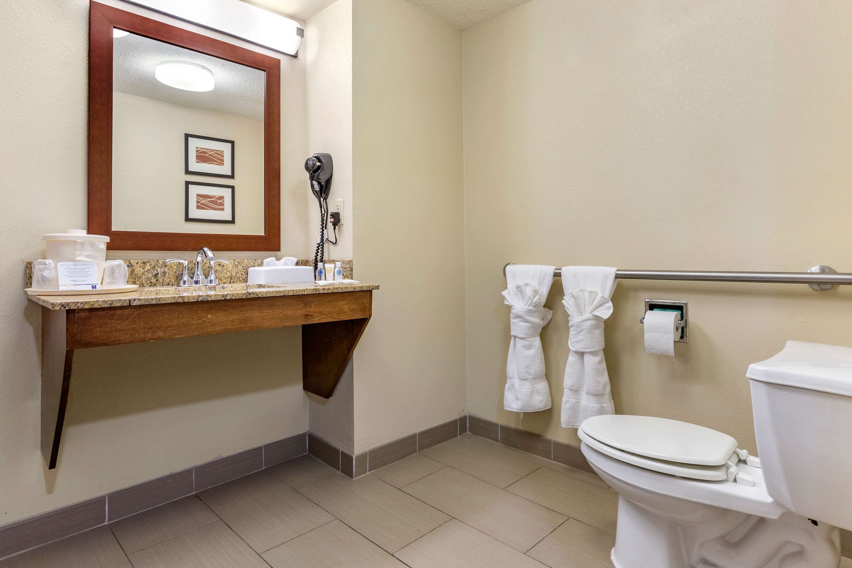 Une salle de bain équipée d’un lavabo, d’un miroir, d’un porte-serviettes et de toilettes.
