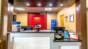 A hotel reception desk with a digital kiosk, a cash register, and a breakfast bar. - Econo Lodge Inn & Suites East Houston I-10 (Houston)