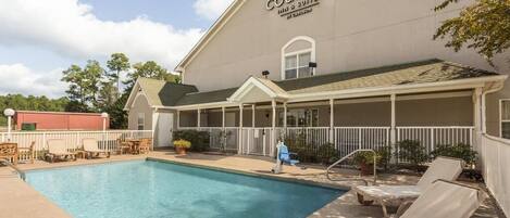 A pool area with lounge chairs and a building labeled "Country Inn & Suites."