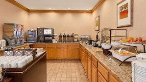 A hotel breakfast area with a coffee station, food display, and a coffee machine. - Country Inn & Suites by Radisson, Biloxi-Ocean Springs, MS (Ocean Springs)