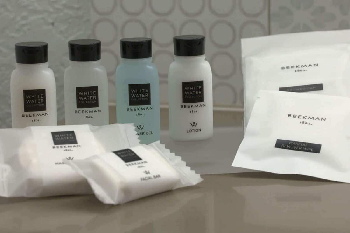 A collection of skincare products from the Beekman brand, including a facial bar, lotion, and a makeup remover wipe.