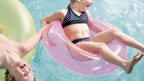 A person floating on a pink inflatable ring in a pool. - Country Inn & Suites by Radisson, Biloxi-Ocean Springs, MS (Ocean Springs)