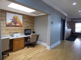Un espacio de oficina moderno con un escritorio de madera, computadora e impresora.