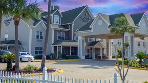 A Country Inn & Suites hotel with a modern architectural design, featuring multiple entry points and a covered parking area. - Country Inn & Suites by Radisson, Biloxi-Ocean Springs, MS (Ocean Springs)
