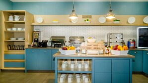 A breakfast bar with a coffee machine, fruit bowl, and cereal box. - Country Inn & Suites by Radisson, Tuscaloosa, AL (Tuscaloosa)