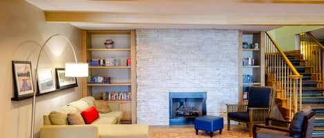Una sala de estar acogedora con chimenea, un sofá, una mesa de centro y una estantería.