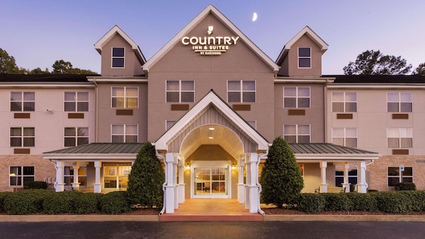 A Country Inn & Suites building with a central entrance, multiple windows, and a sign above the entrance. - Country Inn & Suites by Radisson, Tuscaloosa, AL (Tuscaloosa)