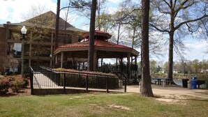 A gazebo with a red roof, surrounded by trees and a grassy area. - Country Inn & Suites by Radisson, Tuscaloosa, AL (Tuscaloosa)