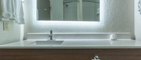 A bathroom with a white sink, mirror, and towel rack.