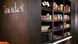 Eine Küchenzeile mit einer Mikrowelle, Regalen voller Snacks und einem Schild mit der Aufschrift 'market'.