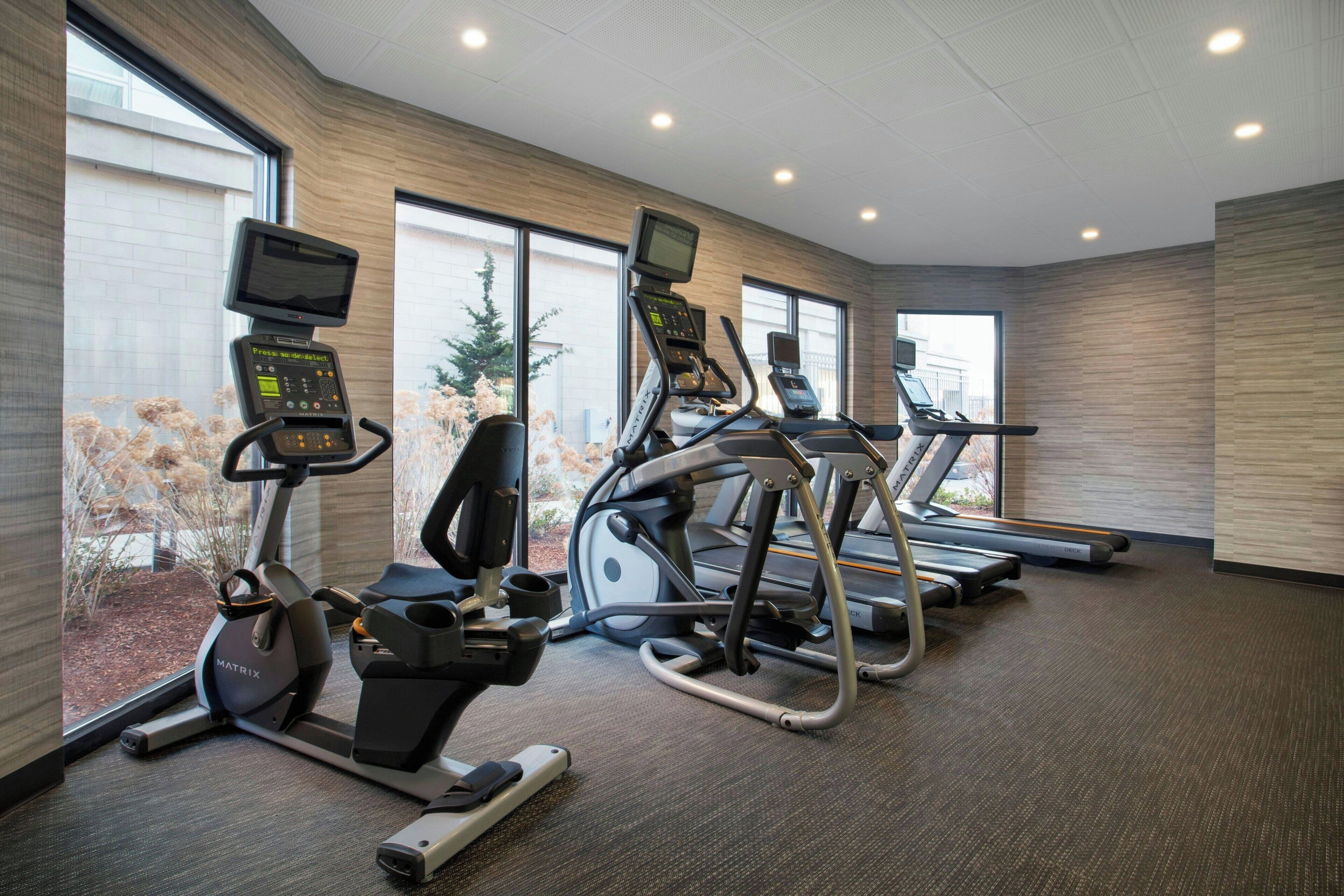 A fitness center with treadmills, elliptical machines, and stationary bikes.