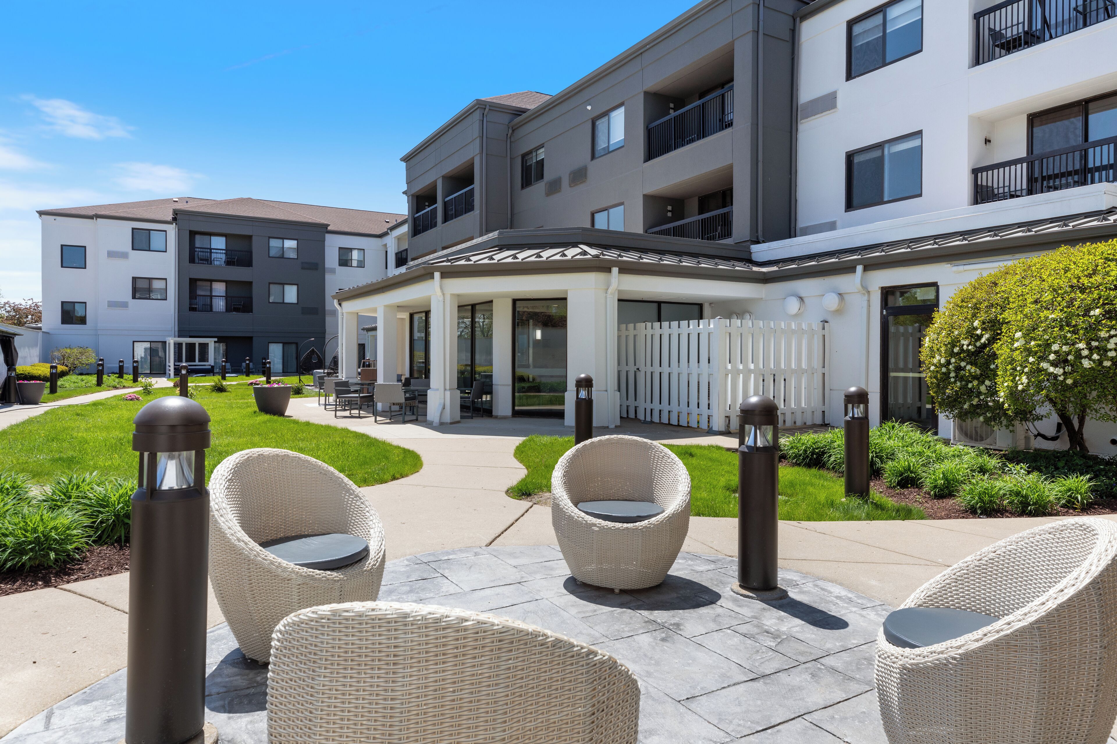 A modern apartment building with outdoor seating and a well-maintained garden.