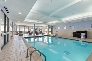 Una piscina techada, sillones reclinables de piscina