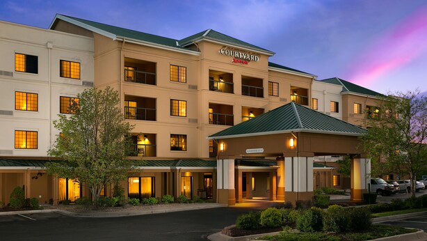 A Courtyard Marriott hotel with a covered entrance, multiple balconies, and a parking area.