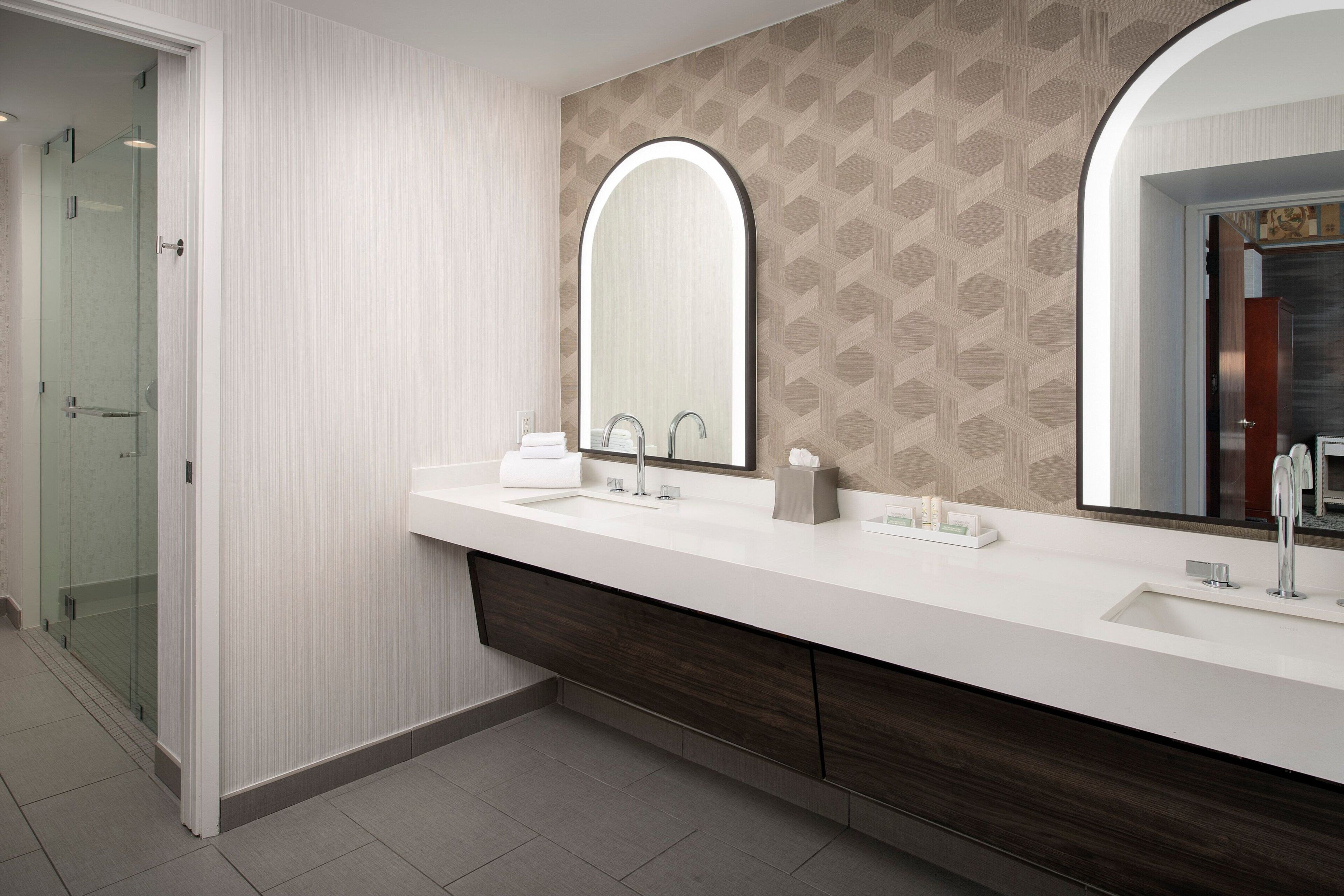 Une salle de bain moderne avec un meuble-lavabo blanc, deux vasques et un grand miroir.