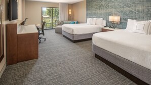 A hotel room with a large bed, a desk, a chair, a TV, and a map on the wall. - Courtyard by Marriott Seattle Sea-Tac Area (Tukwila)