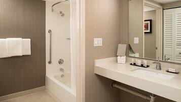 A modern bathroom with a walk-in shower, a bathtub, and a vanity with a sink and mirror.