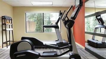 A gym with treadmills, a stationary bike, and a water station.