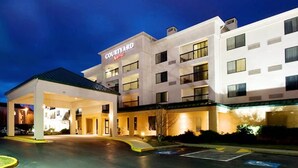 Ett hotell med en innergård, ett tak över parkeringsområdet och flera våningar.