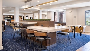 A modern bar area with a central island, bar stools, and pendant lighting. - Courtyard by Marriott Salt Lake City Airport (Salt Lake City)