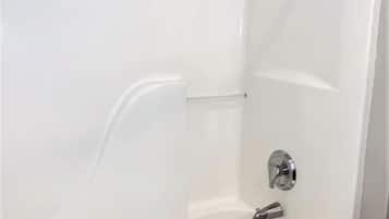 A modern bathroom with a white bathtub, a chrome faucet, and a towel rack.