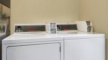 Una secadora comercial blanca con panel de control y una etiqueta que dice "Speed Queen Commercial Dryer".