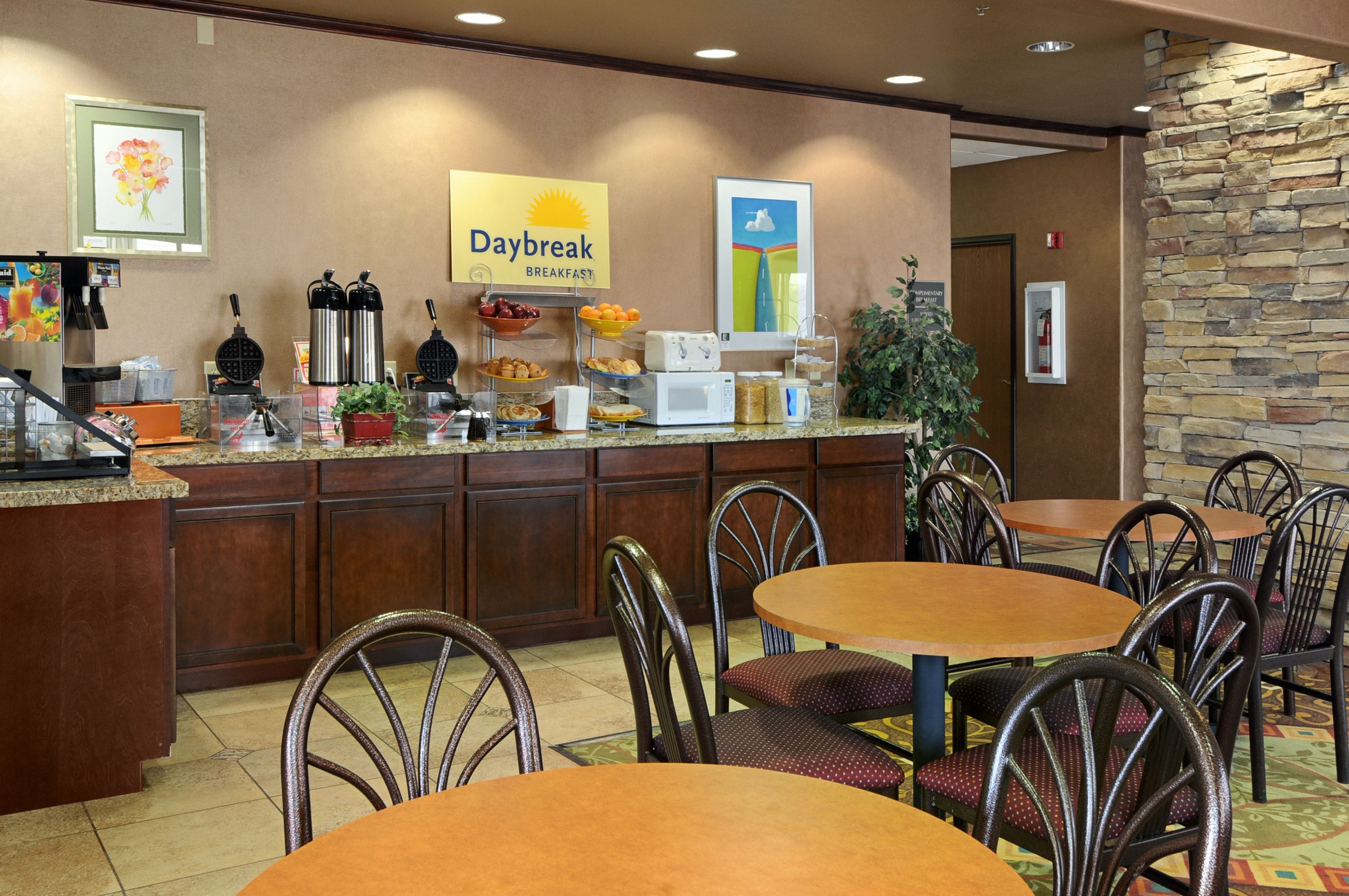 A breakfast area with a counter, chairs, and tables.
