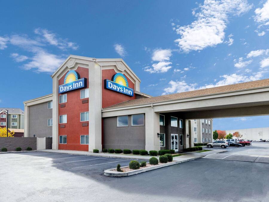 Et Days Inn hotel med parkeringsplads og en klar, blå himmel.