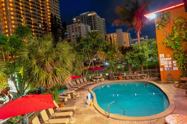 Una piscina al aire libre, sillones reclinables de piscina