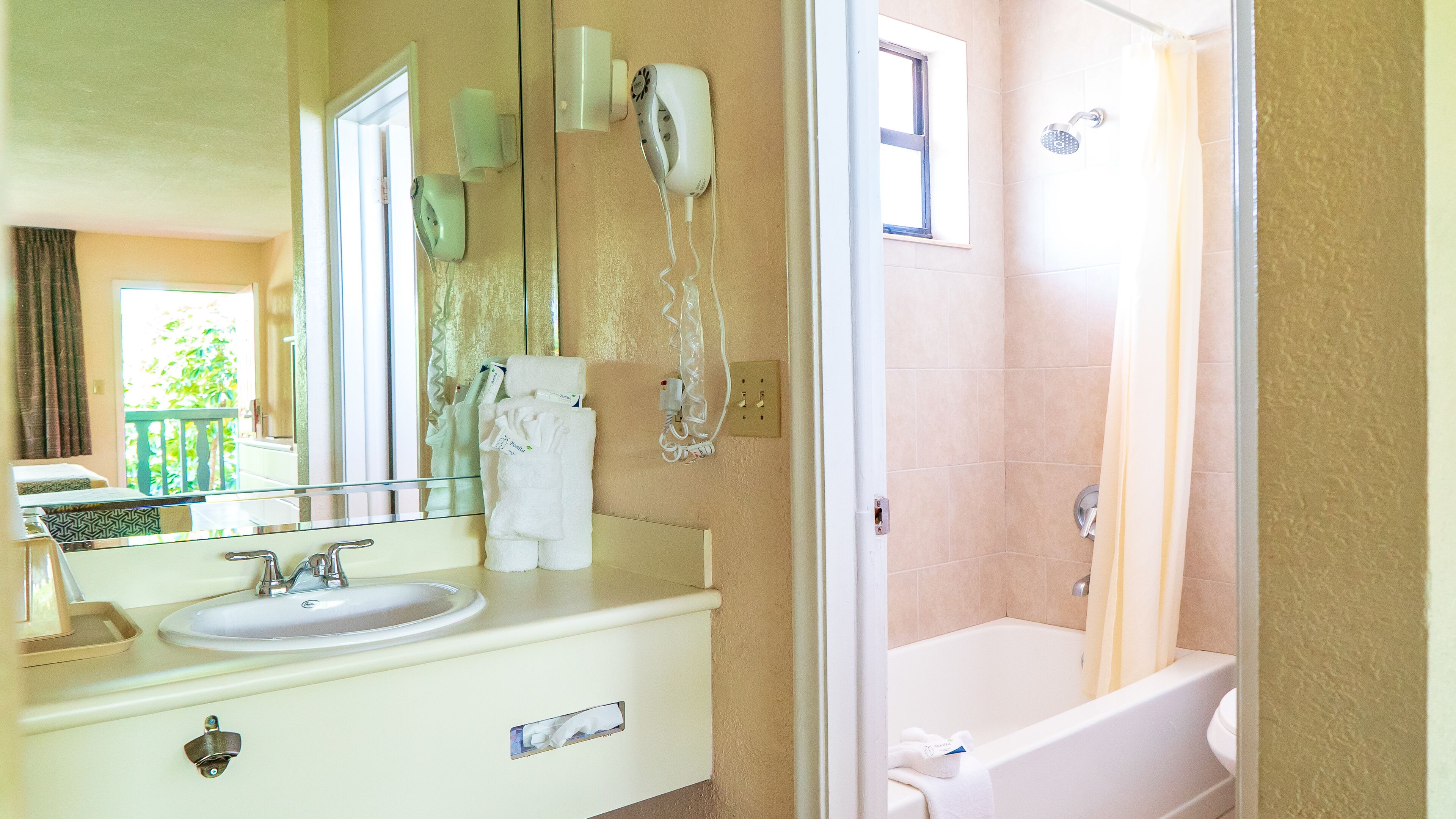 Un baño con lavabo, espejo, toallero y zona de ducha.