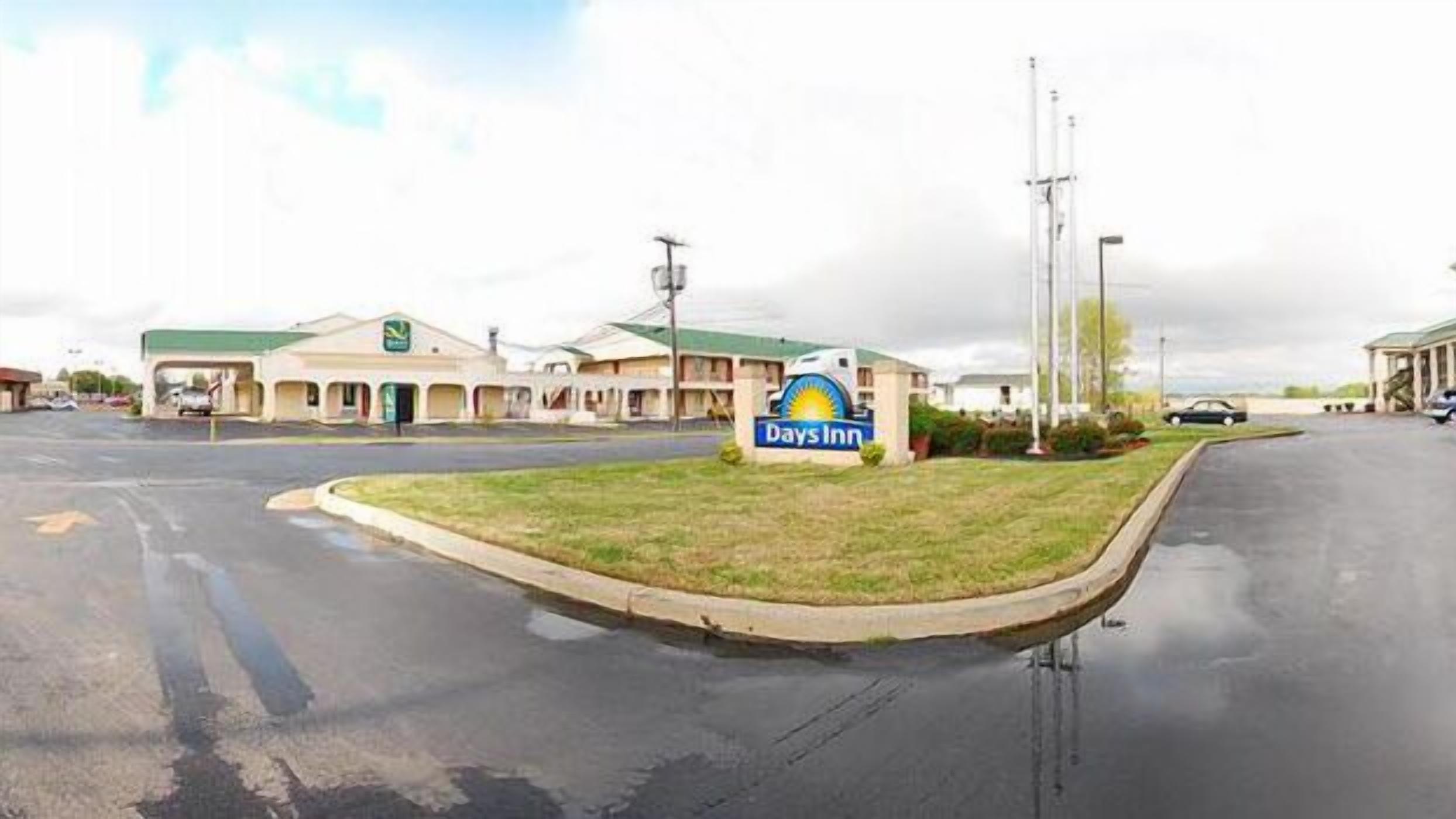 A Days Inn with a parking lot and a grassy area in front.