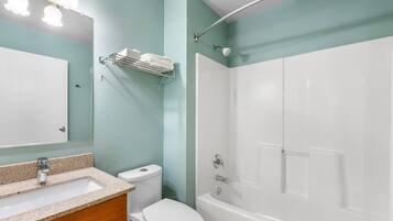 Un baño con lavamanos, inodoro y bañera.