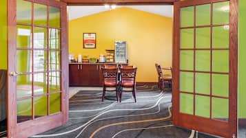 A room with a dining area, a clock on the wall, and a sign that reads "Easy Starts."