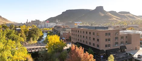 A hotel with a flat roof, a parking lot, and a river in the foreground.