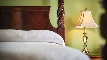 A neatly made bed with a wooden headboard and a bedside table with a lamp.