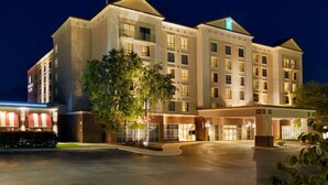 A multi-story hotel with a central entrance, large windows, and a well-lit facade.