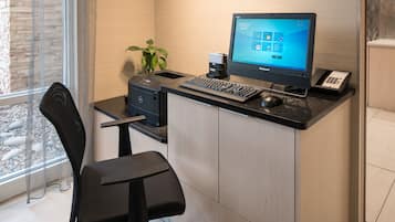 Un bureau moderne, équipé d’un ordinateur de bureau, d’un clavier, d’une souris et d’une petite plante.