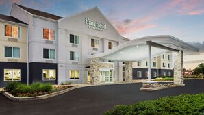 Un hotel Fairfield by Marriott con diseño moderno, que cuenta con una entrada cubierta y un camino de acceso arbolado.
