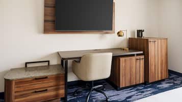 A modern office space with a desk, chair, and a mounted flat-screen TV.