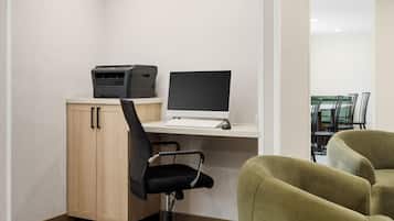 Un espace de travail équipé d’un ordinateur, d’une imprimante et d’un fauteuil de bureau.
