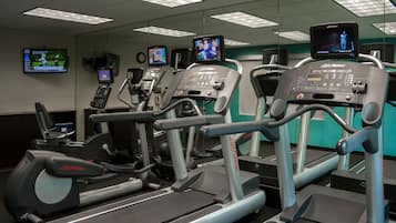 A gym with multiple treadmills, each equipped with digital screens and control panels.