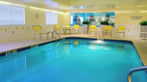 An indoor swimming pool with yellow chairs and tables, a lifeguard sign, and a "No Lifeguard On Duty" sign. - Fairfield Inn by Marriott Huntsville (Huntsville)