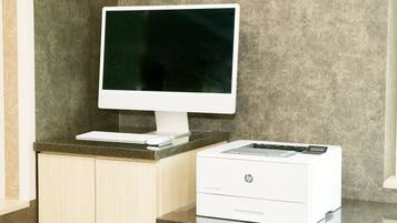 Een bureaubladcomputer met een monitor en een printer op een aanrecht.